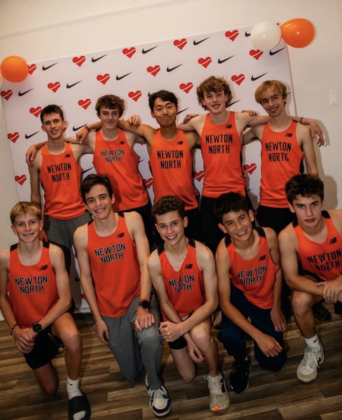 Newton North distance runners posing together in team uniforms